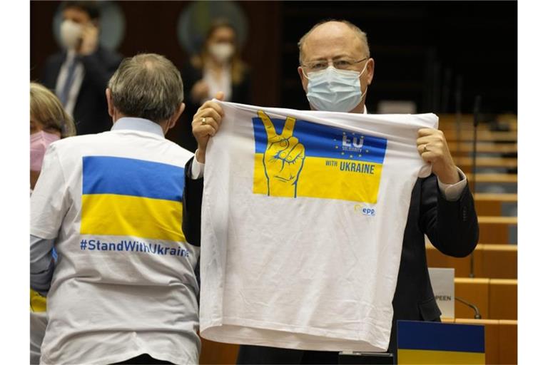 Ein Mitglied des Europäischen Parlaments hält ein T-Shirt in den Farben Blau und Gelb zur Unterstützung der Ukraine. Foto: Virginia Mayo/AP/dpa