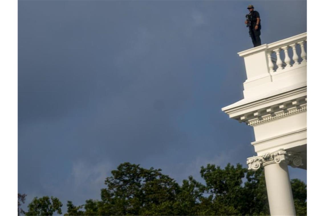 Schüsse vor Weißem Haus: Trump unterbricht Pressekonferenz Ein Mitglied des Secret Service steht zur Sicherung auf dem Dach des Weißen Hauses. Foto: Andrew Harnik/AP/dpa