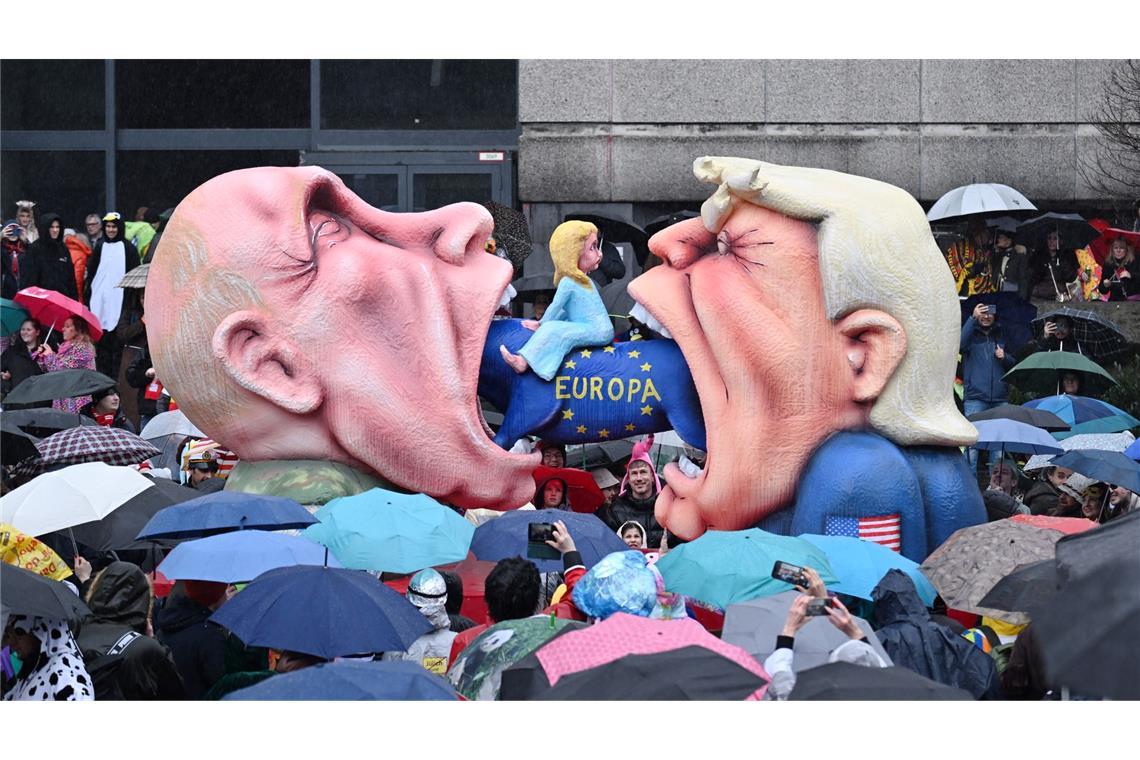 Ein Mottowagen mit Putin und Trump, die versuchen Europa zu fressen, fährt an den Zuschauern beim Rosenmontagszug in Düsseldorf vorbei.