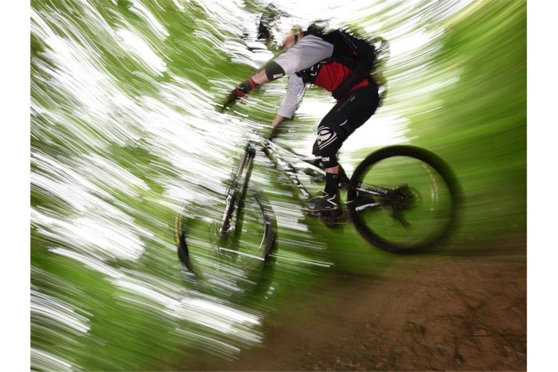 Ein Mountainbiker springt auf dem Canadian Trail bei Freiburg durch den Wald. Foto: picture alliance / dpa/Archivbild