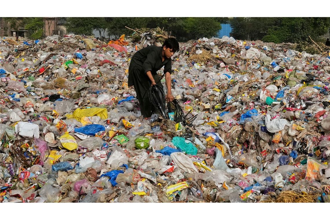 Ein Müllsammler sammelt wiederverwertbare Gegenstände, darunter Plastik, auf einer Mülldeponie in Lahore, Pakistan.