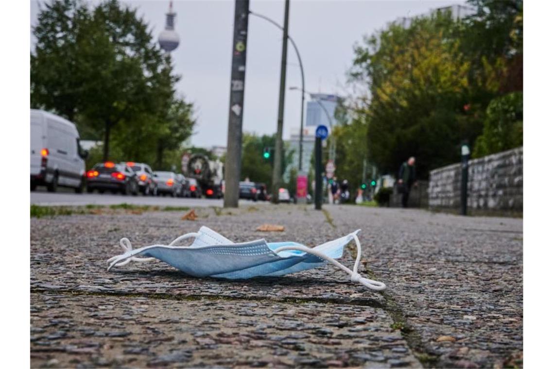 Rufe nach einheitlichen Corona-Reiseregeln in Deutschland Ein Mund-Nasen-Schutz liegt auf dem Gehweg in Berlin-Friedrichshain. Foto: Annette Riedl/dpa