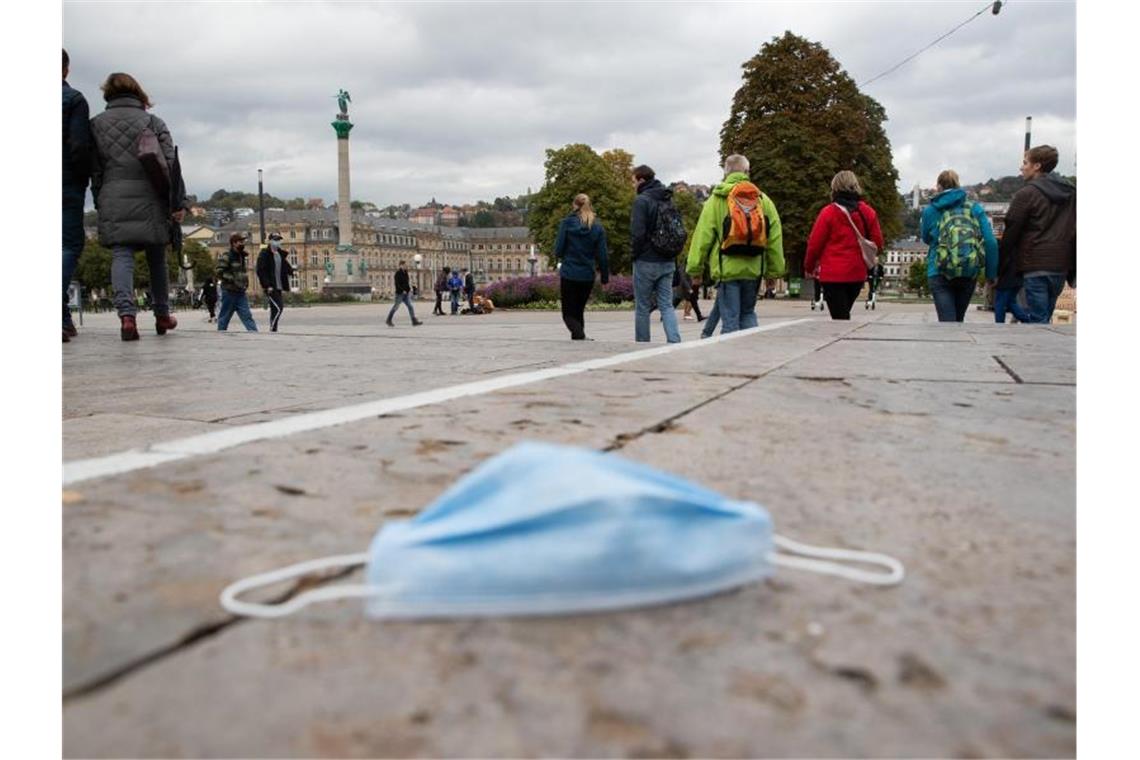 Lockerungen für Handel und private Treffen treten in Kraft Ein Mund-Nasen-Schutz liegt auf dem Stuttgarter Schlossplatz auf dem Boden. Foto: Tom Weller/dpa/Archivbild