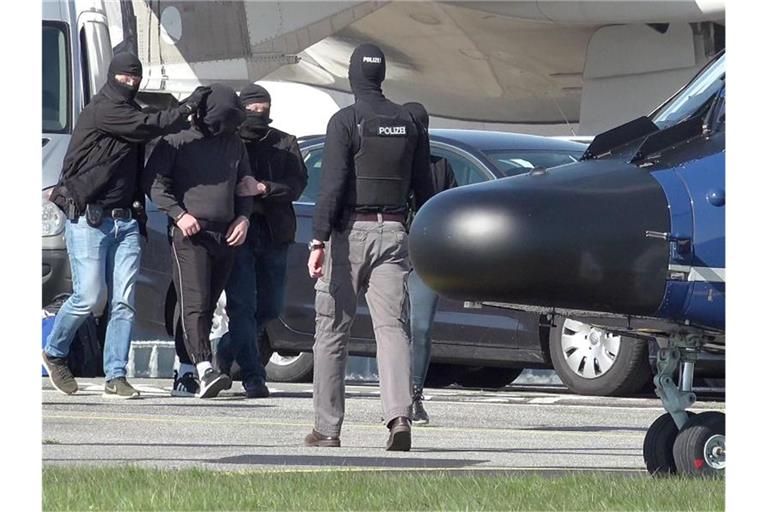 Ein mutmaßliches Mitglied der Terrormiliz IS wird auf dem Flughafen Hamburg zu einem Hubschrauber der Bundespolizei gebracht. Foto: Bodo Marks/dpa