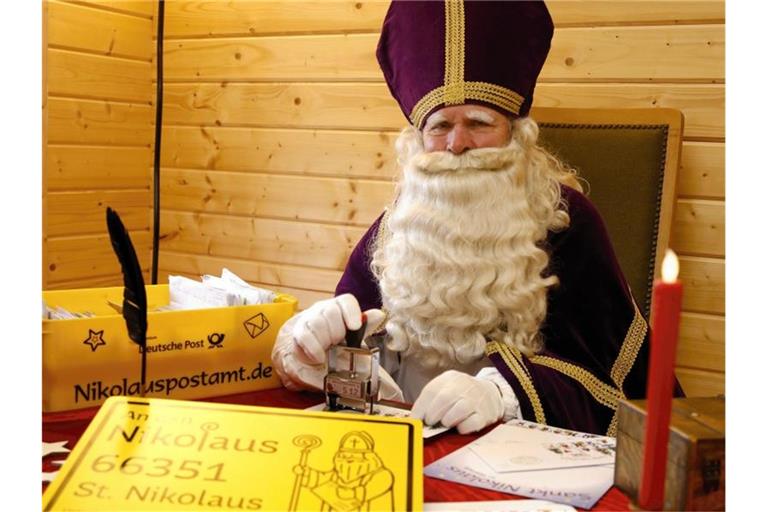 Ein Nikolaus sitzt in seiner Nikolaushütte des Nikolauspostamtes in St. Nikolaus und beantwortet Briefe. Foto: Peter Gerecke/ Festausschuss St. Nikolaus e.V./dpa