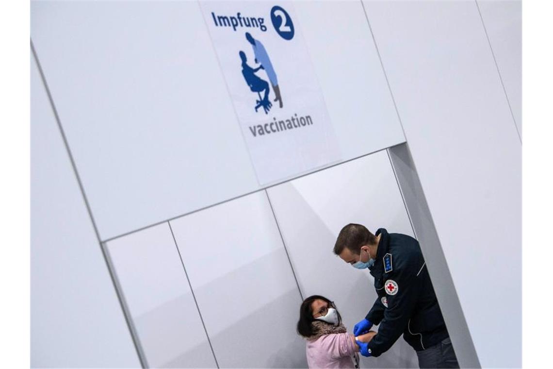 Vorbereitungen für Impfungen laufen auf Hochtouren Ein Notfallsanitäter simuliert an einer Freiwilligen in der Impfkabine eines Impfzentrums in einer Sporthalle den Ablauf einer Corona-Impfung. Foto: Boris Roessler/dpa