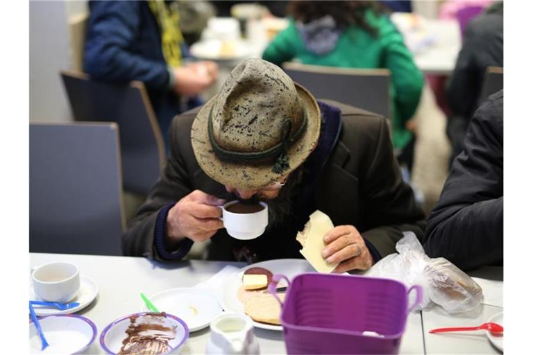 Ein Obdachloser frühstückt in einer Wohnungsloseneinrichtung in Dortmund. Foto: Ina Fassbender/dpa