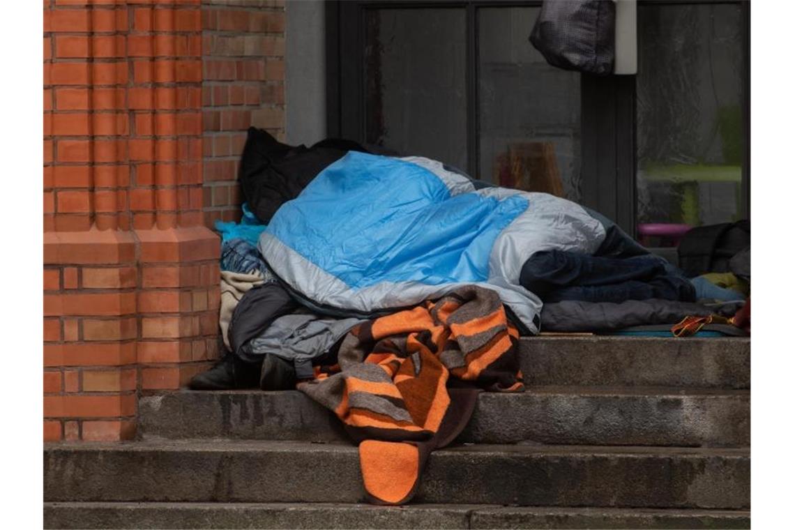 Ein Obdachloser liegt in einem Eingang einer Kirche in Berlin. Obdachlos sind den Zahlen der Wohungslosenhilfe zufolge etwa 41.000 Menschen in Deutschland. Foto: Paul Zinken/dpa