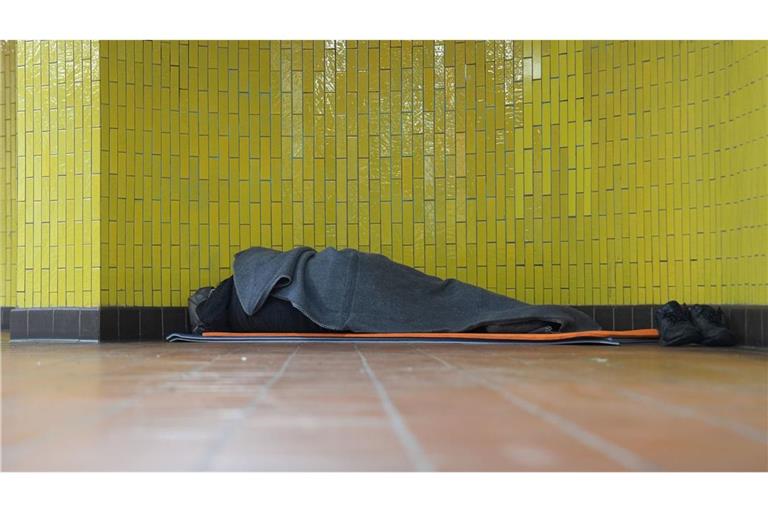 Ein Obdachloser liegt in seinem Schlafsack in einer U-Bahnstation in der Hamburger Innenstadt. 17,7 Millionen Menschen waren 2023 in Deutschland von Armut oder Ausgrenzung bedroht.