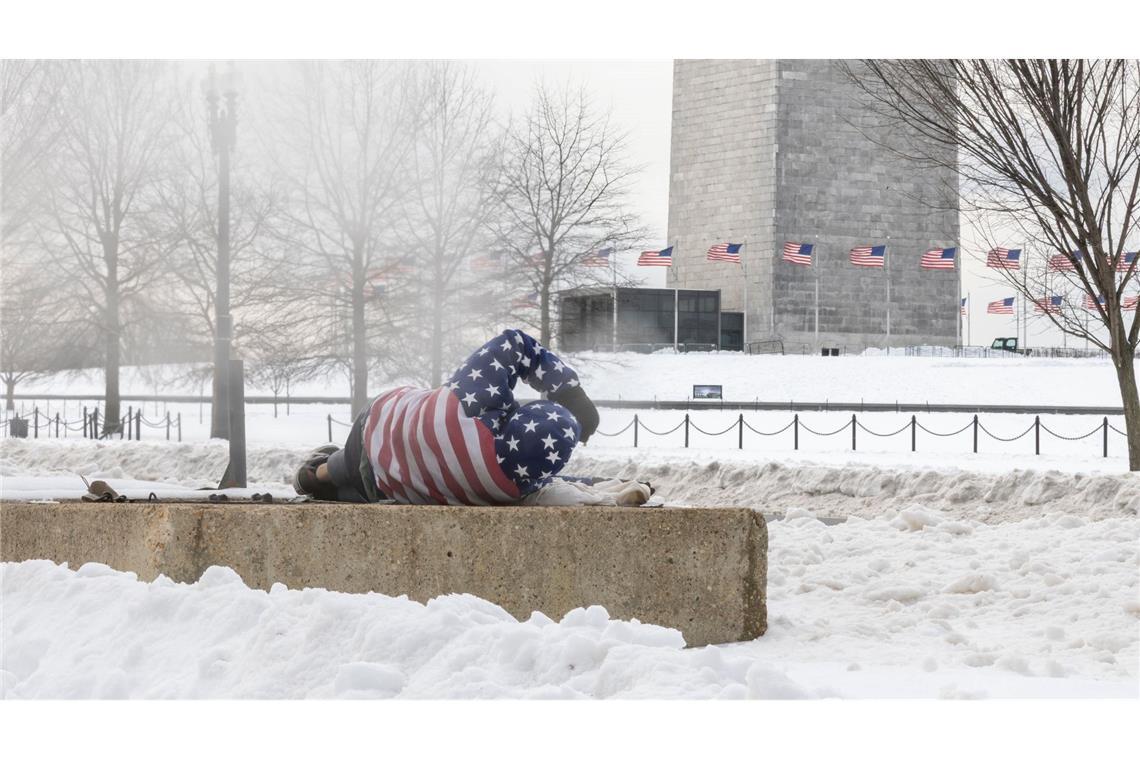 Ein Obdachloser ruht sich nach einem schweren Wintersturm in der Nähe des Washington Monuments auf.