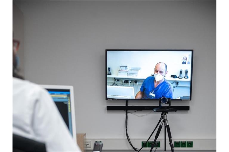 Ein Oberarzt spricht über eine Videoschaltung mit einem Techniker. Foto: Sebastian Gollnow/dpa