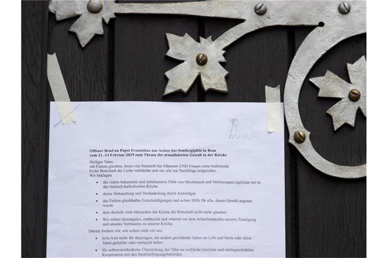 Ein Offener Brief an Papst Franziskus hängt an der Tür der katholischen Kirche „Heilig Kreuz“ in Münster. Foto: Friso Gentsch