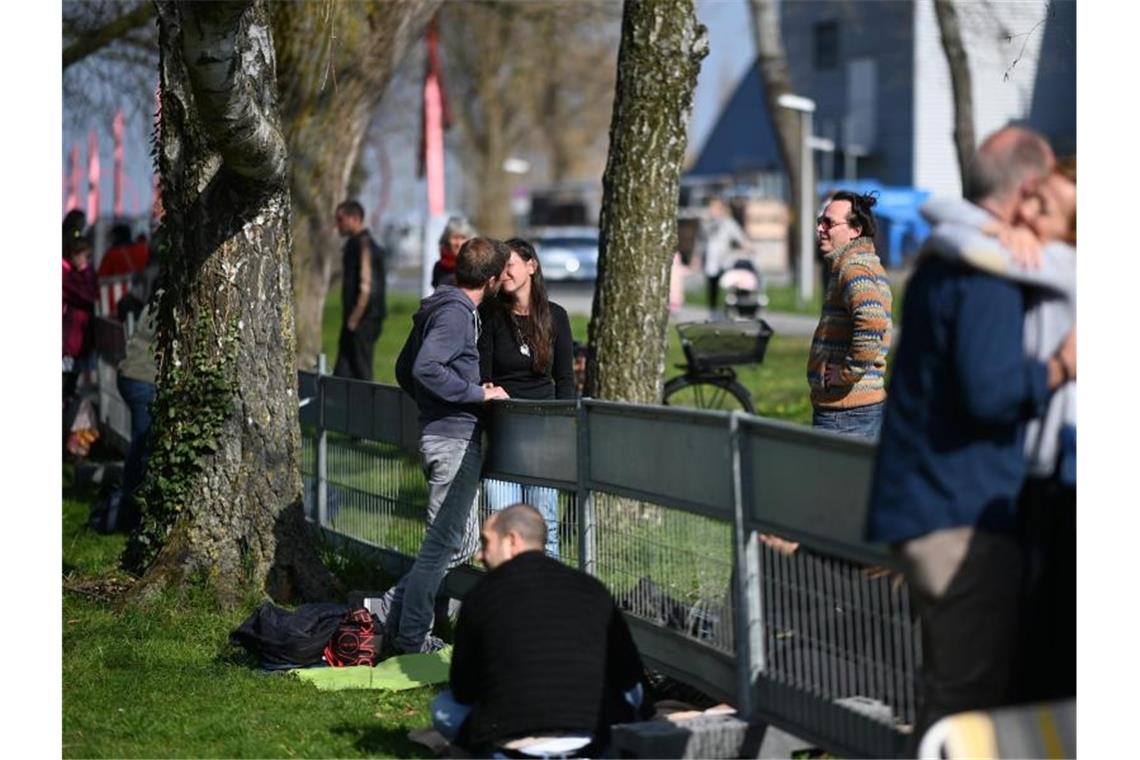 Corona: Schwere Zeiten für grenzüberschreitende Liebe Ein Paar küsst sich an der Deutsch-Schweizer Grenze zwischen Konstanz und Kreuzlingen. Foto: Felix Kästle/dpa