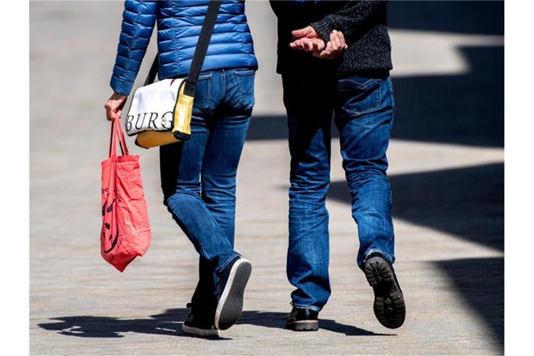 Ein Paar mit einer Einkaufstasche beim Einkaufsbummel. Foto: Hauke-Christian Dittrich/dpa;