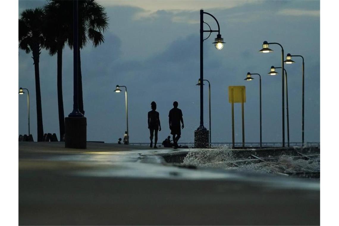 Ein Paar spaziert am Ufer des Lake Pontchartrain in New Orleans, während sich der Hurrikan „Ida“ nähert. Foto: Eric Gay/AP/dpa