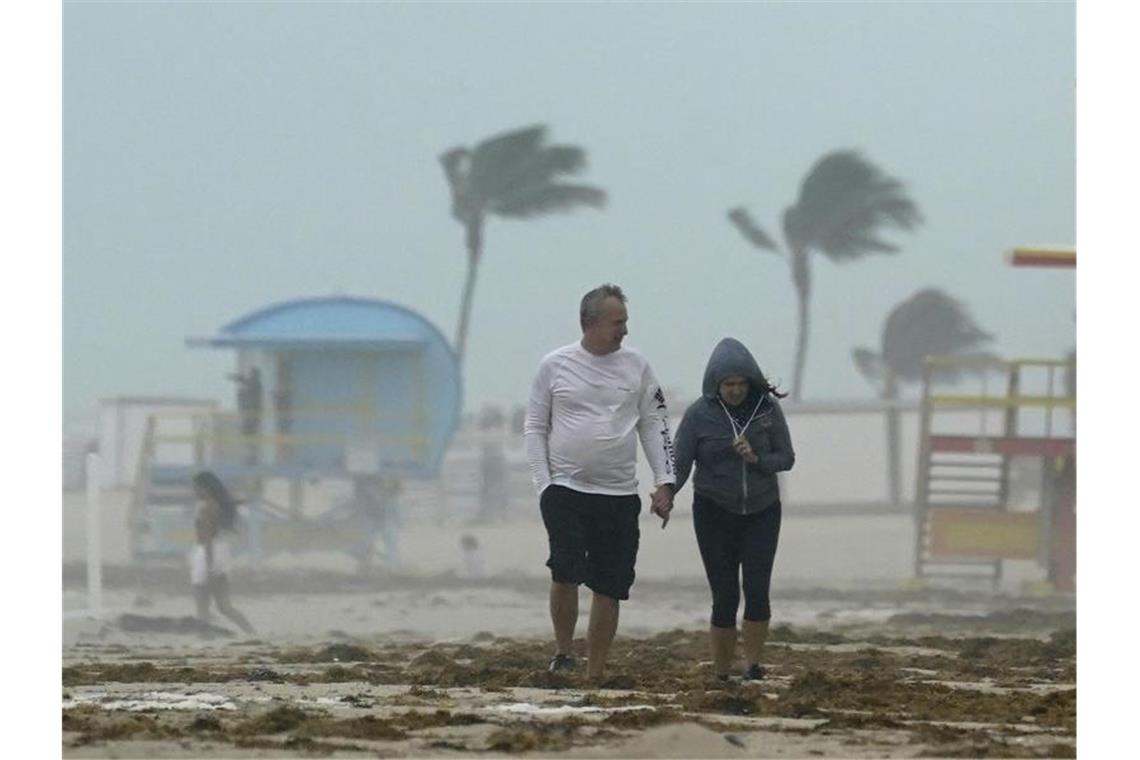 Ein Paar spaziert während des heftigen Tropensturms am Strand von Miami Beach entlang. Foto: Wilfredo Lee/AP/dpa