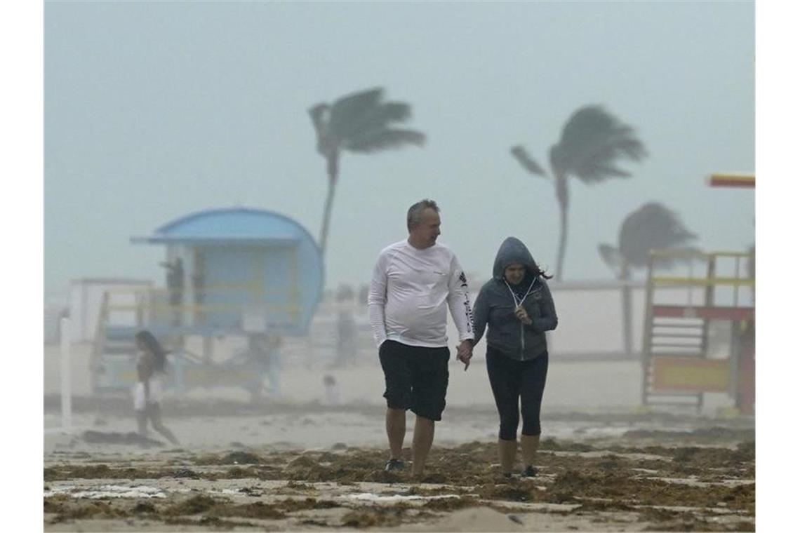 Tropensturm „Eta“ vor Florida Ein Paar spaziert während des heftigen Tropensturms am Strand von Miami Beach entlang. Foto: Wilfredo Lee/AP/dpa
