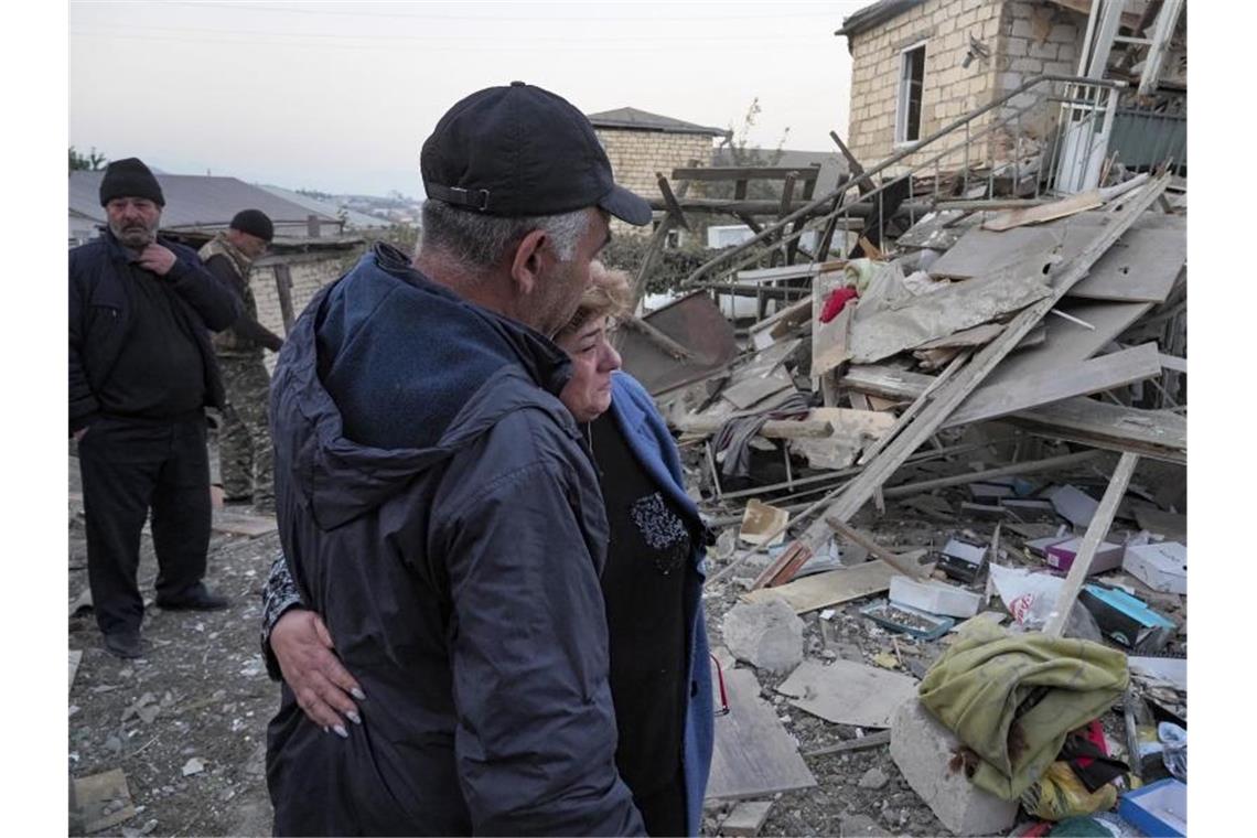 Waffenruhe in Berg-Karabach scheitert Ein Paar steht vor den Trümmern eines zerstörten Hauses in Berg-Karabach. Foto: Uncredited/AP/dpa