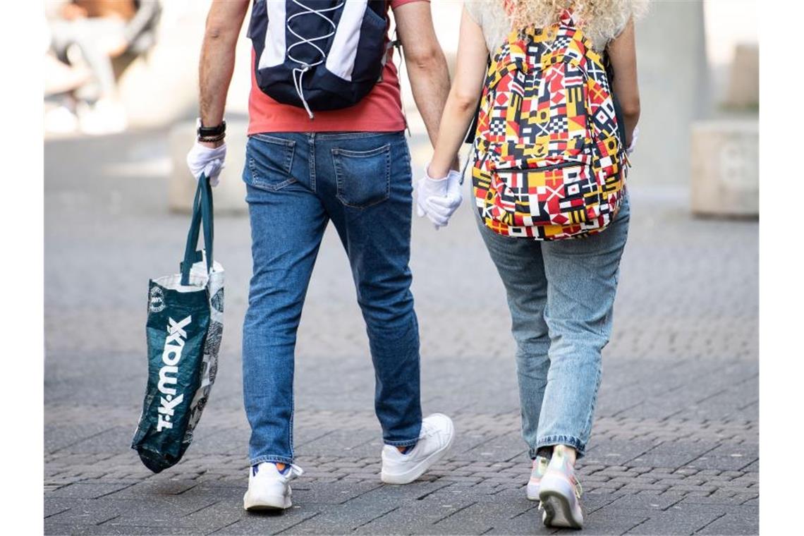 Erster Shopping-Samstag in Corona-Krise verläuft ruhig Ein Pärchen trägt während eines Einkaufsbummels auf der Schildergasse in Köln Schutzhandschuhe. Foto: Marius Becker/dpa
