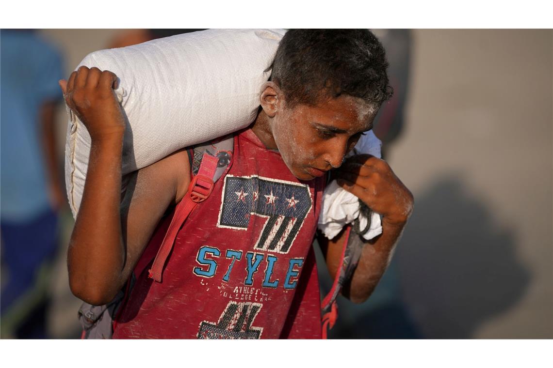 Hilfsgüter für Gaza: Warum sie oft nicht ankommen Ein palästinensischer Junge trägt einen Sack Mehl. (Archivbild)
