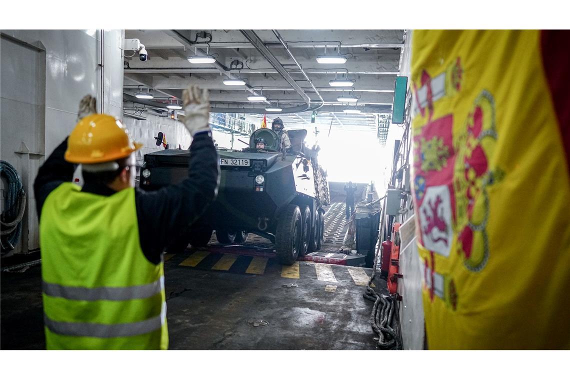 Ein Panzer wird vom Flagschiff auf ein Landeboot verladen.