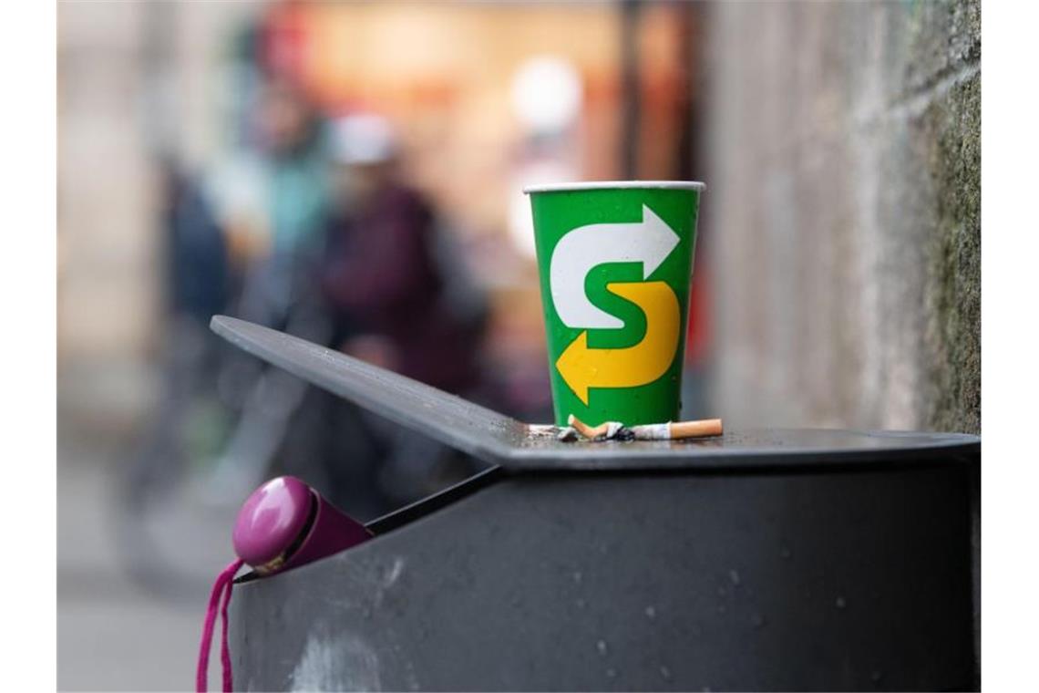 Ein Pappbecher steht auf einem Mülleimer bei der Stiftskirche. Foto: Marijan Murat/dpa/Symbolbild