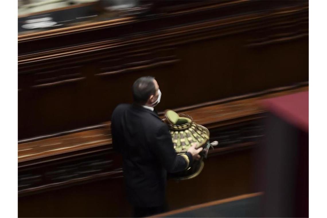 Italien: Amtierender Staatschef Mattarella wiedergewählt Ein Parlamentsangestellter sammelt eine Wahlurne im italienischen Parlament ein. Foto: Filippo Monteforte/Pool AFP/AP/dpa
