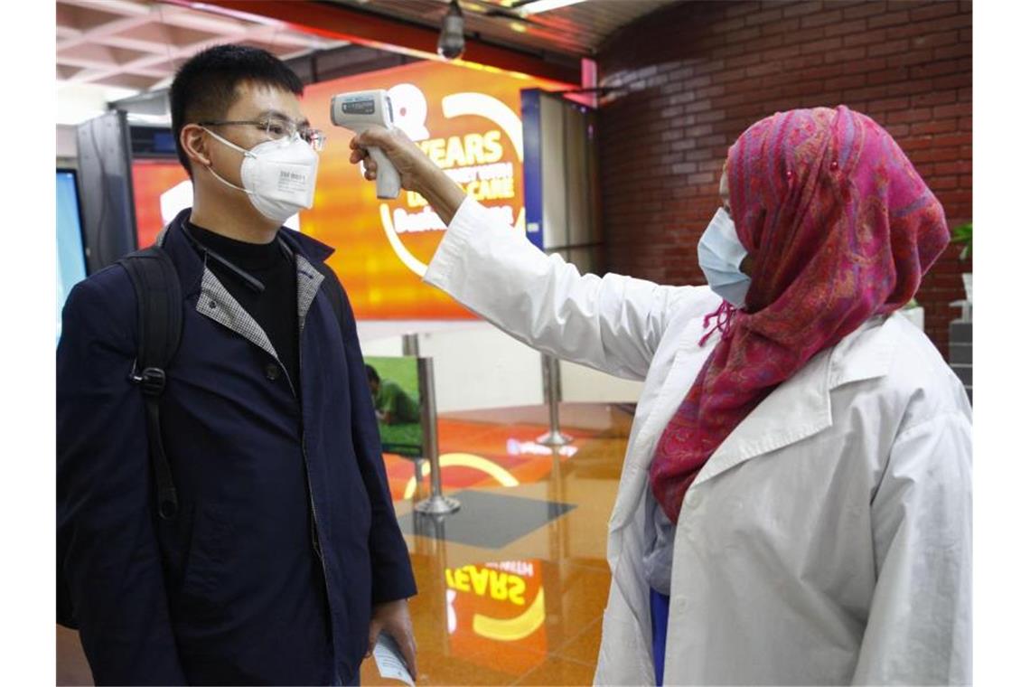 Ein Passagier aus Peking wird am Flughafen Dhaka in Bangladesch untersucht. Foto: Al-Emrun Garjon/AP/dpa