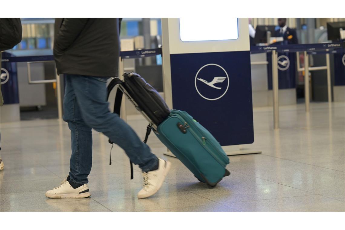 Ein Passagier läuft an einem Lufthansa-Schalter vorbei. Bei der Lufthansa gehen am Donnerstag Piloten und Flugbegleiter gleichzeitig in einen ganztägigen Streik.