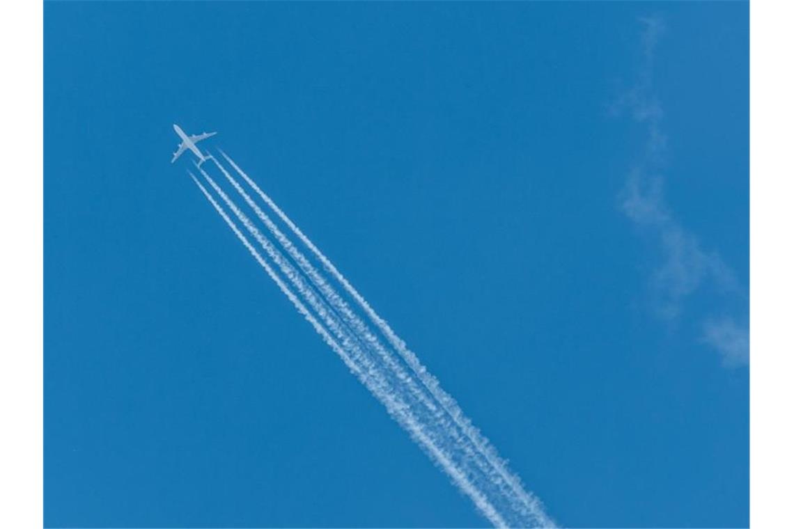 Ein Passagierflugzeug zieht Kondensstreifen hinter sich her. Foto: Robert Michael/Archivbild