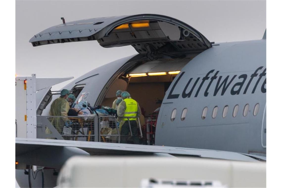 Luftwaffe hilft bei Verlegung von Corona-Patienten Ein Patient wird in ein Flugzeug der Bundeswehr auf dem Flughafen Memmingen gebracht. Foto: Peter Kneffel/dpa