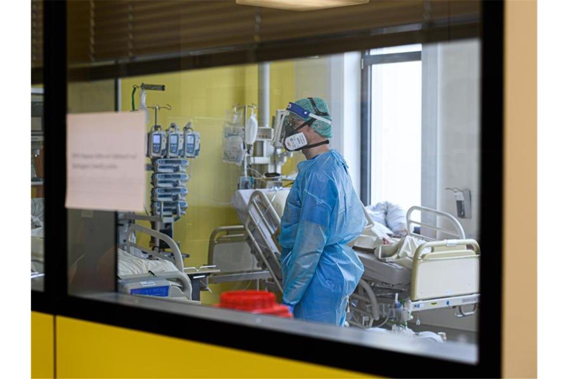 So viele Covid 19-Patienten wie nie auf Intensivstationen Ein Pfleger versorgt auf einer Covid-19-Intensivstation Corona-Patienten. Foto: Robert Michael/dpa-Zentralbild/dpa/Symbolbild