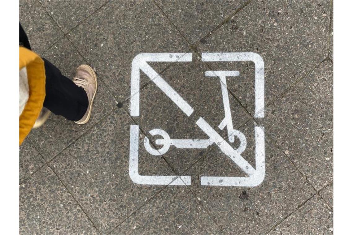 Ein Piktogramm auf einem Gehweg zeigt, dass E-Scooter-Fahrer hier nicht fahren und wild parken dürfen. Foto: Paul Zinken/dpa
