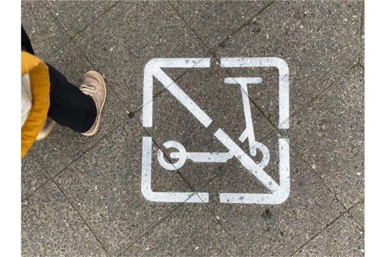 Ein Piktogramm auf einem Gehweg zeigt, dass E-Scooter-Fahrer hier nicht fahren und wild parken dürfen. Foto: Paul Zinken/dpa