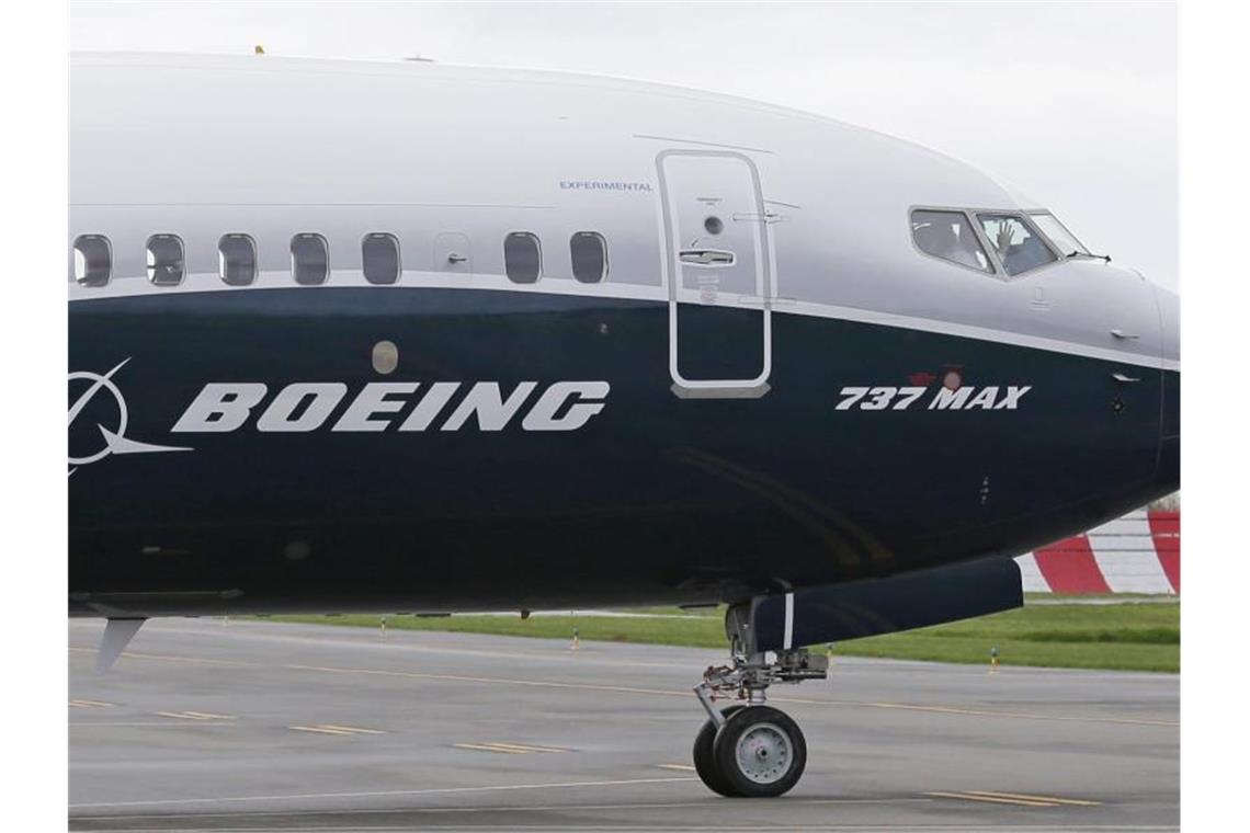 Ein Pilot winkt aus der Pilotenkabine eines Flugzeuges vom Typ Boeing 737 MAX auf dem Flughafen. Foto: Ted S. Warren/AP/dpa