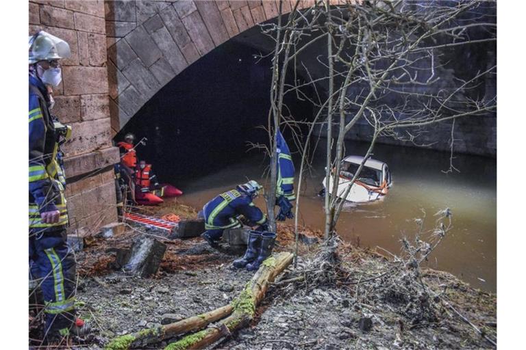 Ein Pkw liegt unterhalb einer Brücke am Fluss Kocher in Künzelsau. Foto: Fabian Koss/onw-images/dpa