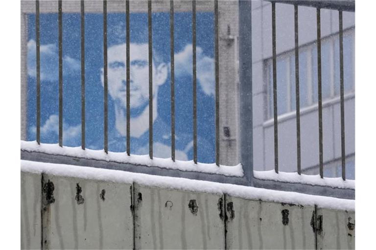 Ein Plakat mit dem Konterfei des serbischen Tennisspielers Novak Djokovic hängt an einem Gebäude. Foto: Darko Vojinovic/AP/dpa