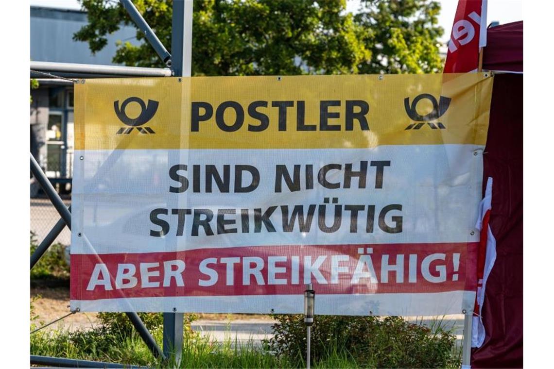 Tausende Postler machen bei Warnstreiks mit Ein Plakat vor einem Briefzentrum der Post im bayerischen Straubing. Foto: Armin Weigel/dpa