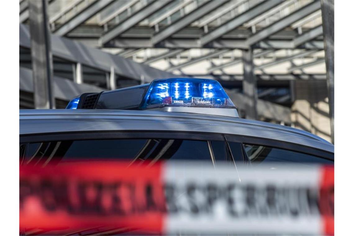 Ein Polizei-Blaulicht leuchtet über einem Absperrband mit der Aufschrift „Polizeiabsperrung“. Foto: David Inderlied/dpa/Illustration