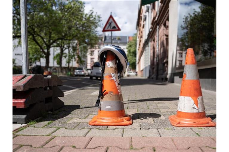 Ein Polizei-Fahrradhelm iegt auf eine Pylone, die eine Straße im dicht besiedelten Frankfurter Nordend absperrt, nachdem dort bei Baggerarbeiten eine Weltkriegsbombe entdeckt wurde. Foto: Frank Rumpenhorst/dpa