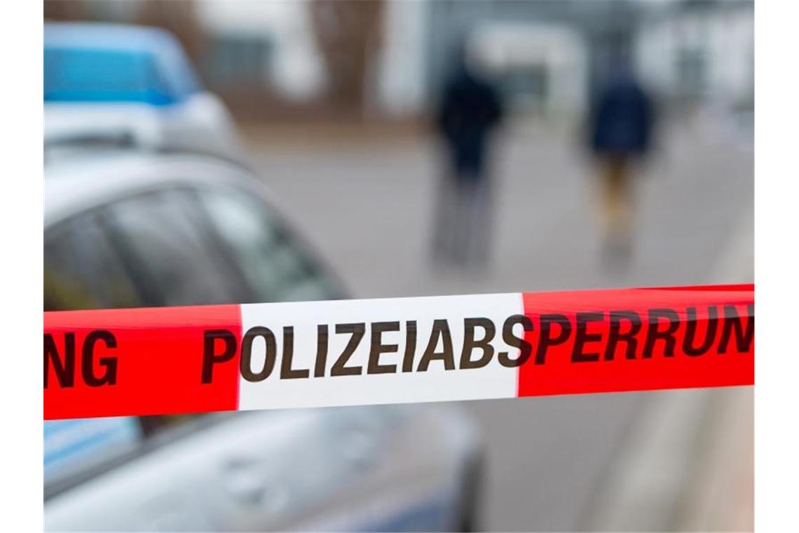 Ein Polizeiabsperrband vor einem Polizeiwagen. Foto: Marc Tirl/ZB/dpa/Symbolbild