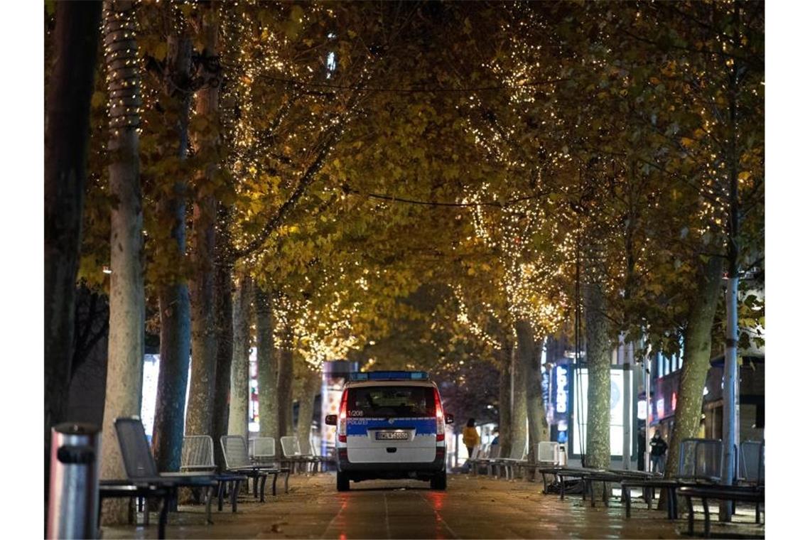 Ein Polizeiauto fährt durch die leere Innenstadt von Stuttgart. Foto: Sebastian Gollnow/dpa