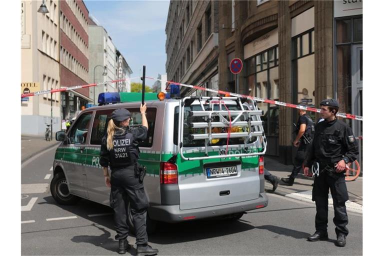 Ein Polizeiauto fährt unter der Absperrung durch. Foto: Oliver Berg