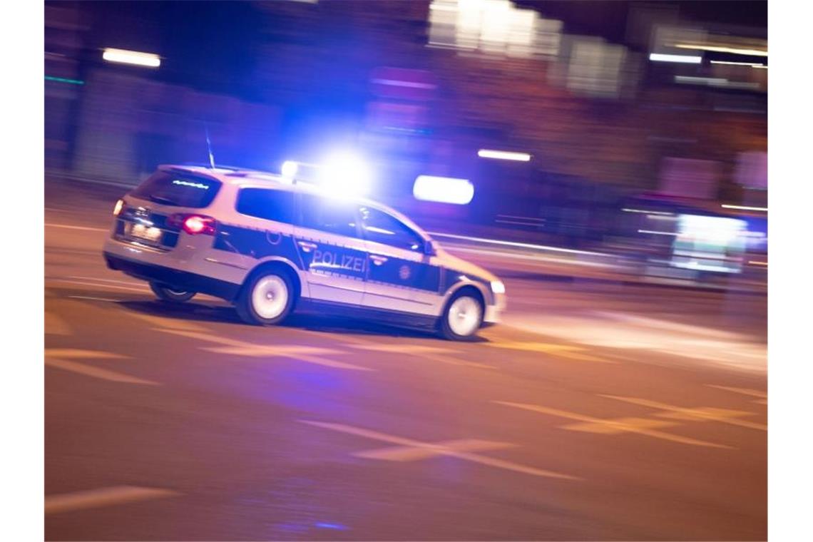 Ein Polizeiauto fährt unter Einsatz von Blaulicht und Sirene eine Straße entlang. Foto: Lino Mirgeler/Archiv