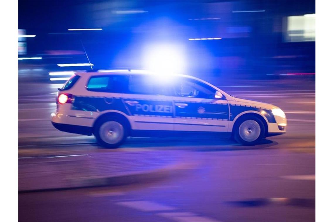 Ein Polizeiauto fährt unter Einsatz von Blaulicht und Sirene eine Straße entlang. Foto: Lino Mirgeler/Archivbild