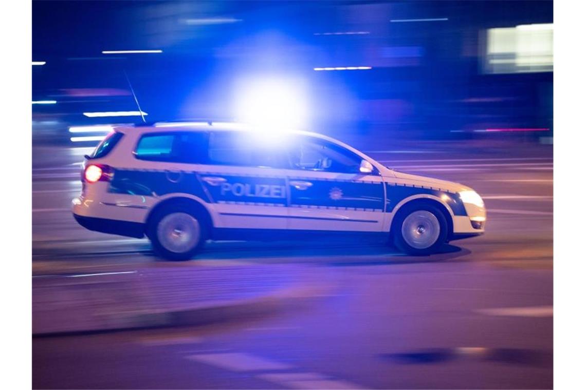 Ein Polizeiauto fährt unter Einsatz von Blaulicht und Sirene eine Straße entlang. Foto: Lino Mirgeler/dpa/Archivbild