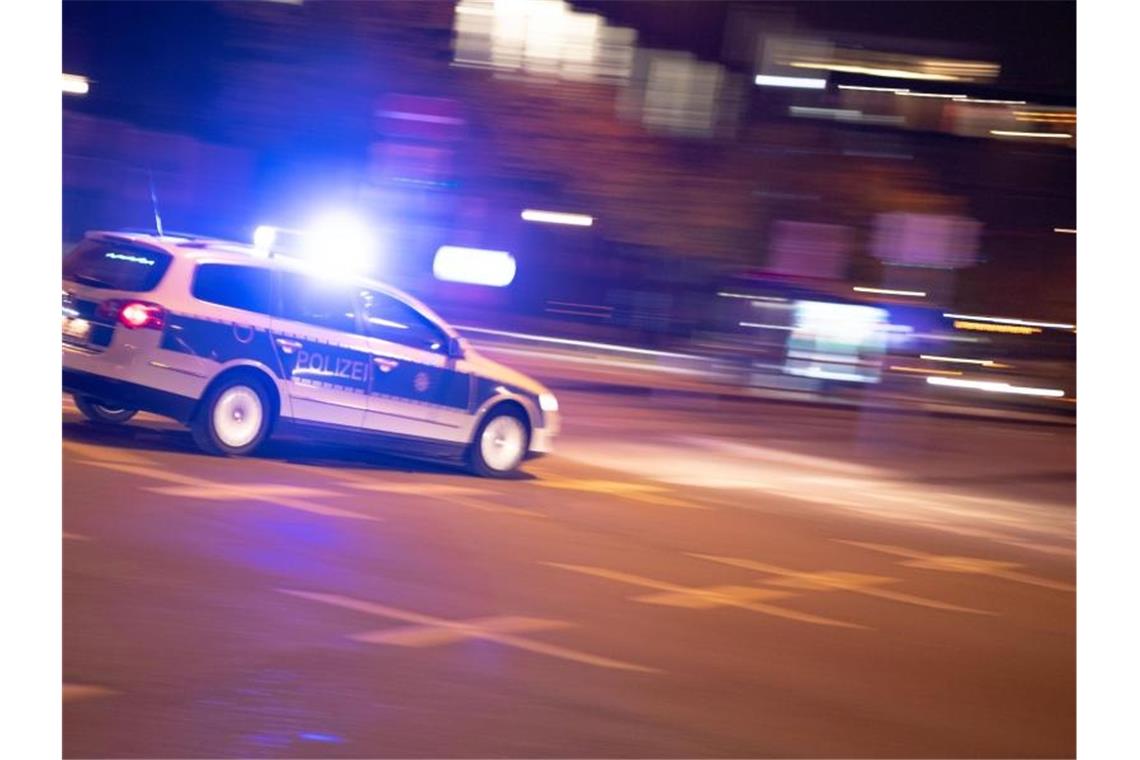 Ein Polizeiauto fährt unter Einsatz von Blaulicht und Sirene eine Straße entlang. Foto: Lino Mirgeler/dpa/Symbolbild