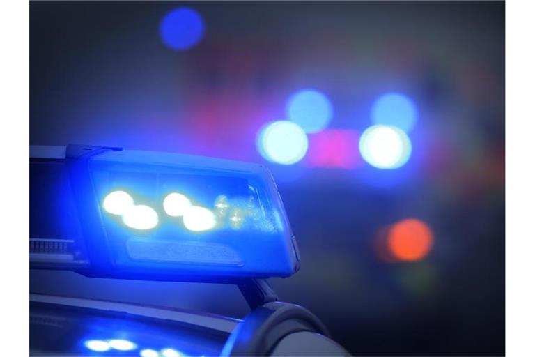 Ein Polizeiauto mit eingeschaltetem Blaulicht steht an einer Unfallstelle. Foto: Karl-Josef Hildenbrand/dpa