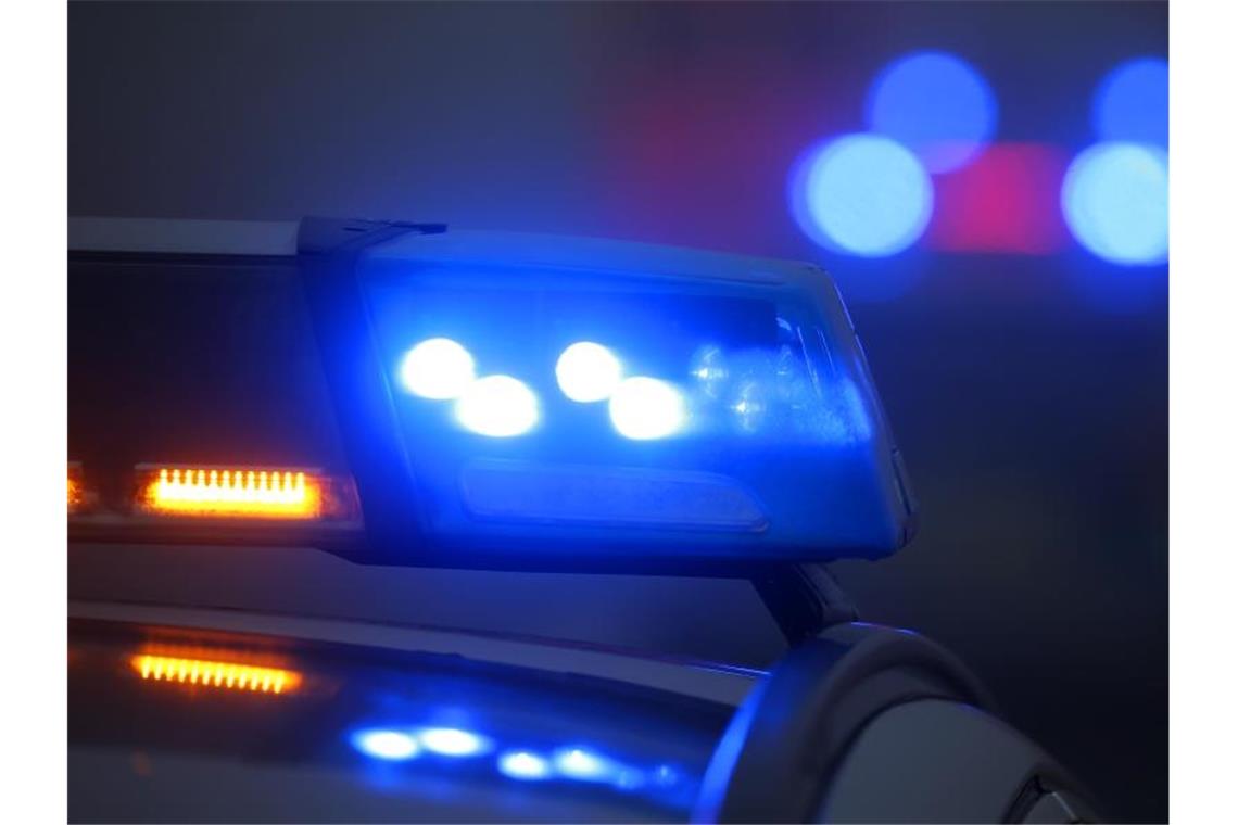 Ein Polizeiauto mit eingeschaltetem Blaulicht steht an einer Unfallstelle. Foto: Karl-Josef Hildenbrand/dpa/Archivbild
