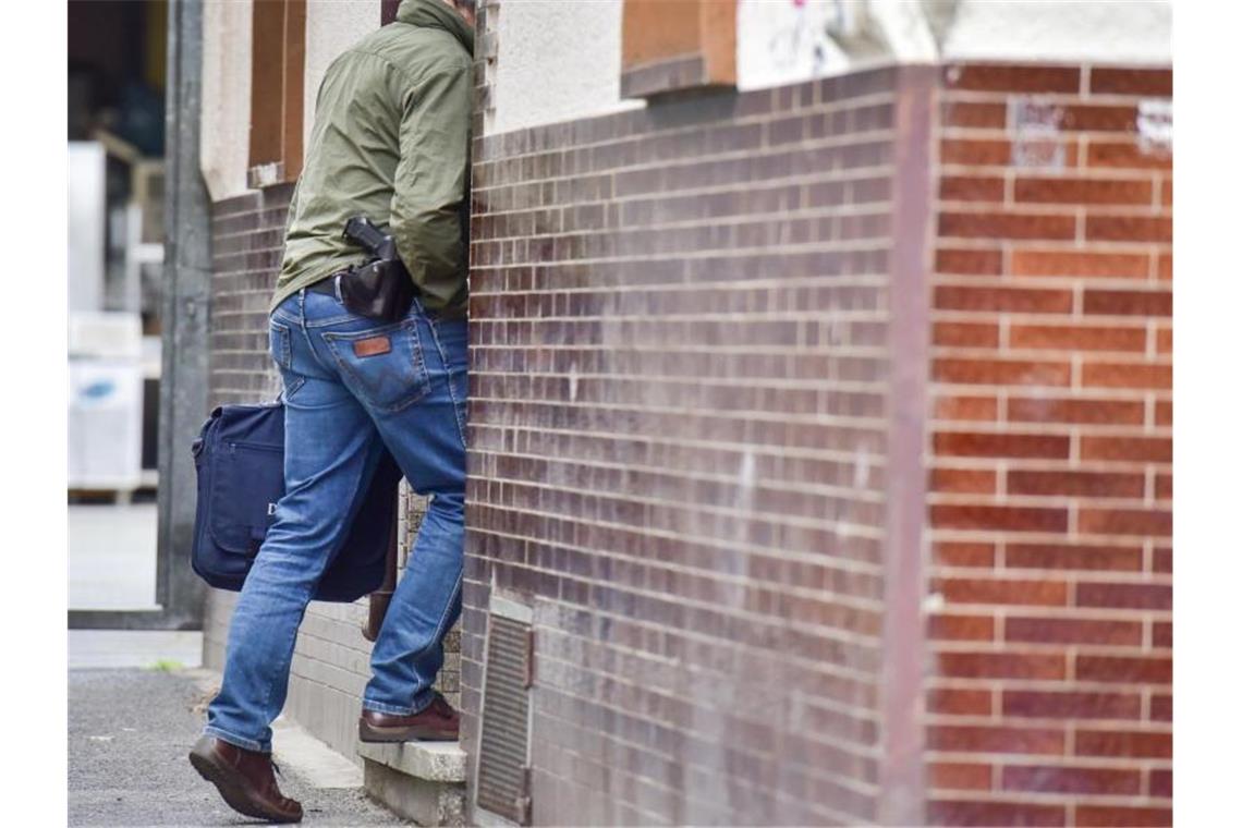 Razzien nach Gewalt gegen Polizisten Ein Polizeibeamter betritt ein Haus in Bonn. Laut Staatsanwaltschaft konnten die Beamten mutmaßliche Beweismittel sicherstellen. Foto: Benjamin Westhoff/dpa